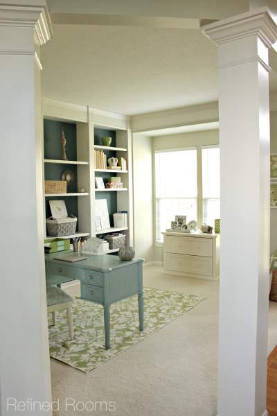 contemporary home office with built in book shelves and blue accents.