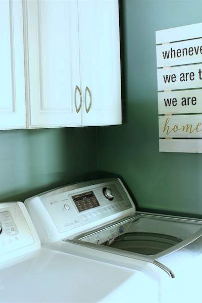 teal colored laundry room with white appliances.
