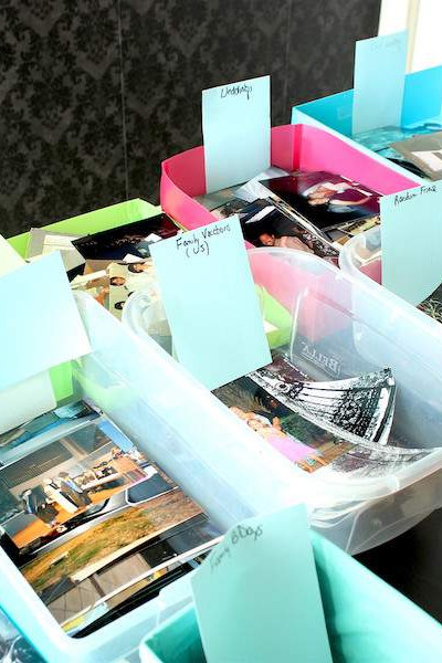 boxes of sorted paper photos on top of card tables.