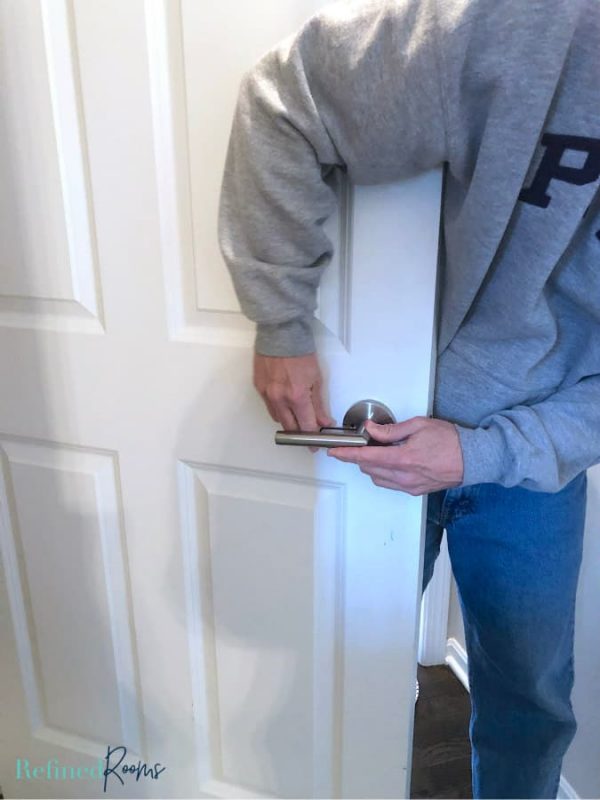man installing doorknob.