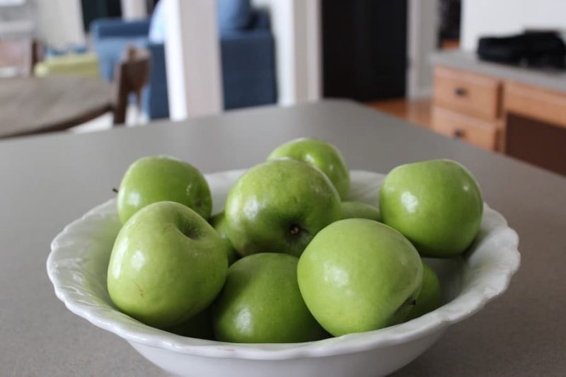 large bowl of green apples as staging decor in kitchen