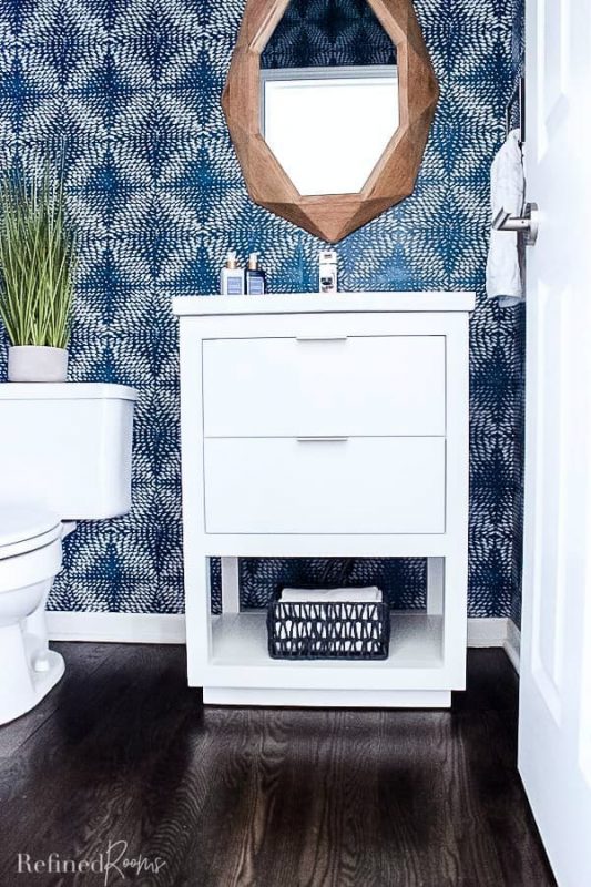 modern white bathroom vanity and sink with towel storage basket.