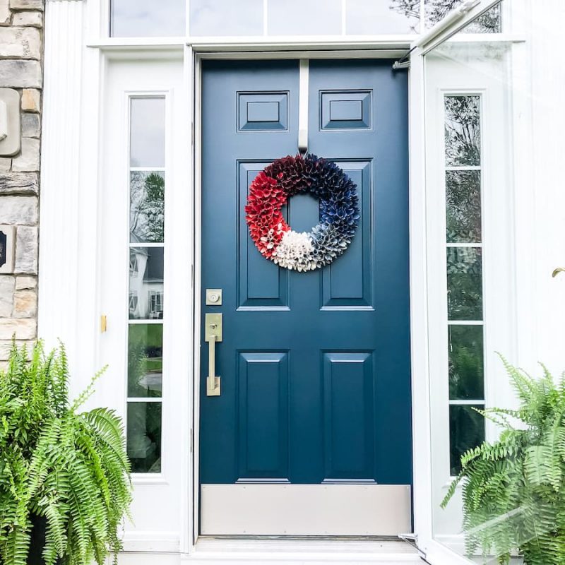 front door exterior with wreath and ferns.