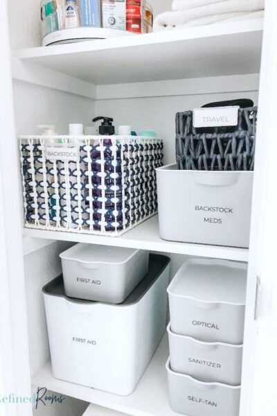 organized medicine cabinet with labeled storage containers.