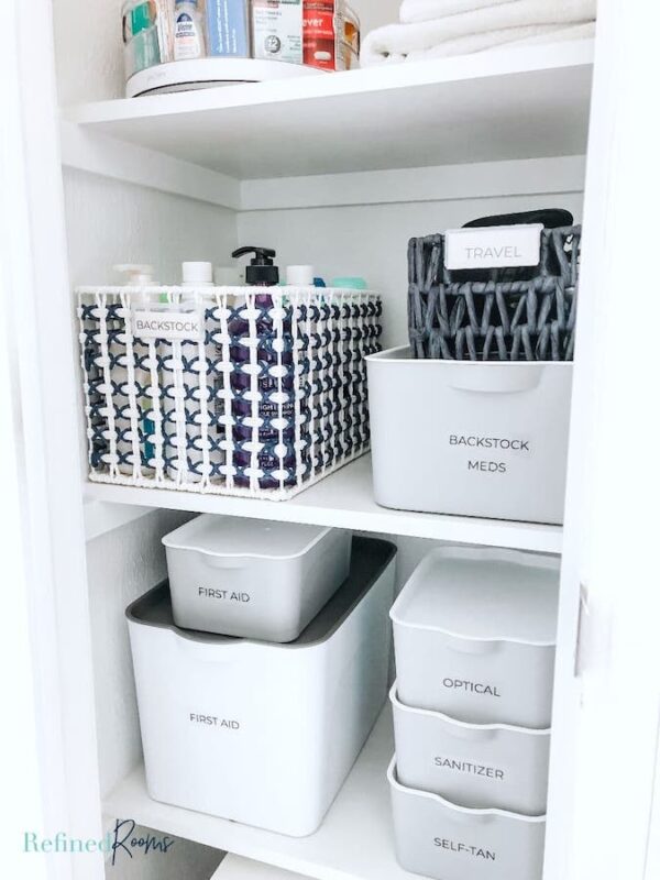 organized medicine cabinet with labeled storage containers.